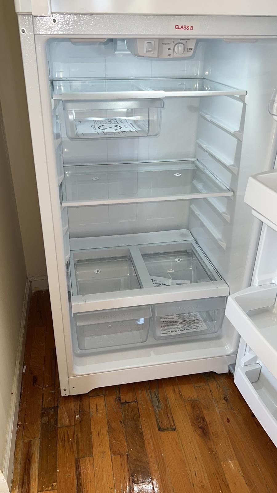 An empty refrigerator cleaned inside, shelves and drawers spotless