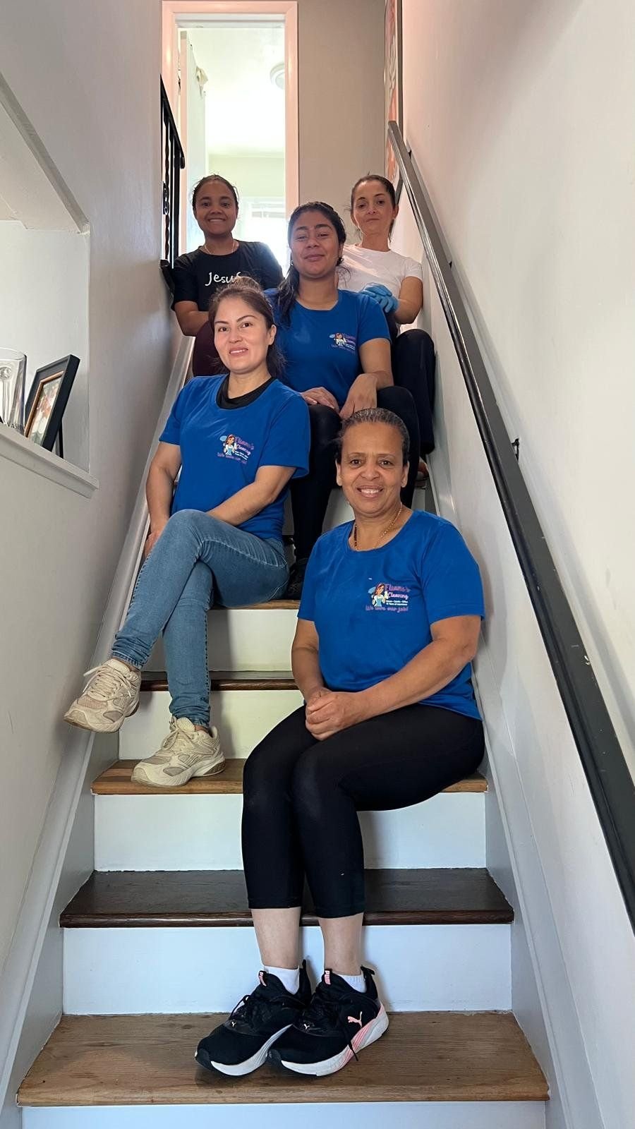 The Eliane's Cleaning team in matching blue uniforms on a staircase